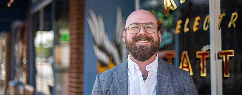 Professor Aaron Perzanowski with a tatto shop in the background
